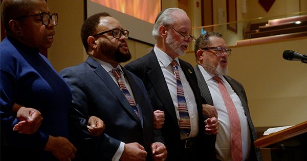 A unity event involving members of the Tree of Life and Ebenezer Baptist congregations singing the Civil Rights anthem “We Shall Overcome”. 