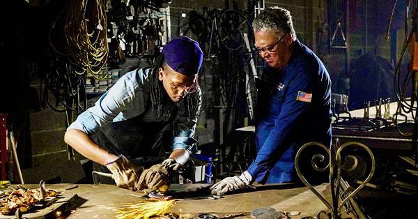 Darryl Reeves (right), a third generation blacksmith and welder, works with his son in workshop New Orleans.