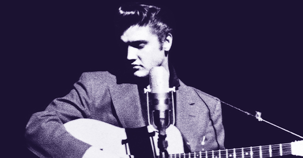 Promotional image of Elvis Presley in a suit seated with an acoustic guitar, looking down beside a vintage microphone. The black-and-white image evokes a classic recording studio performance.